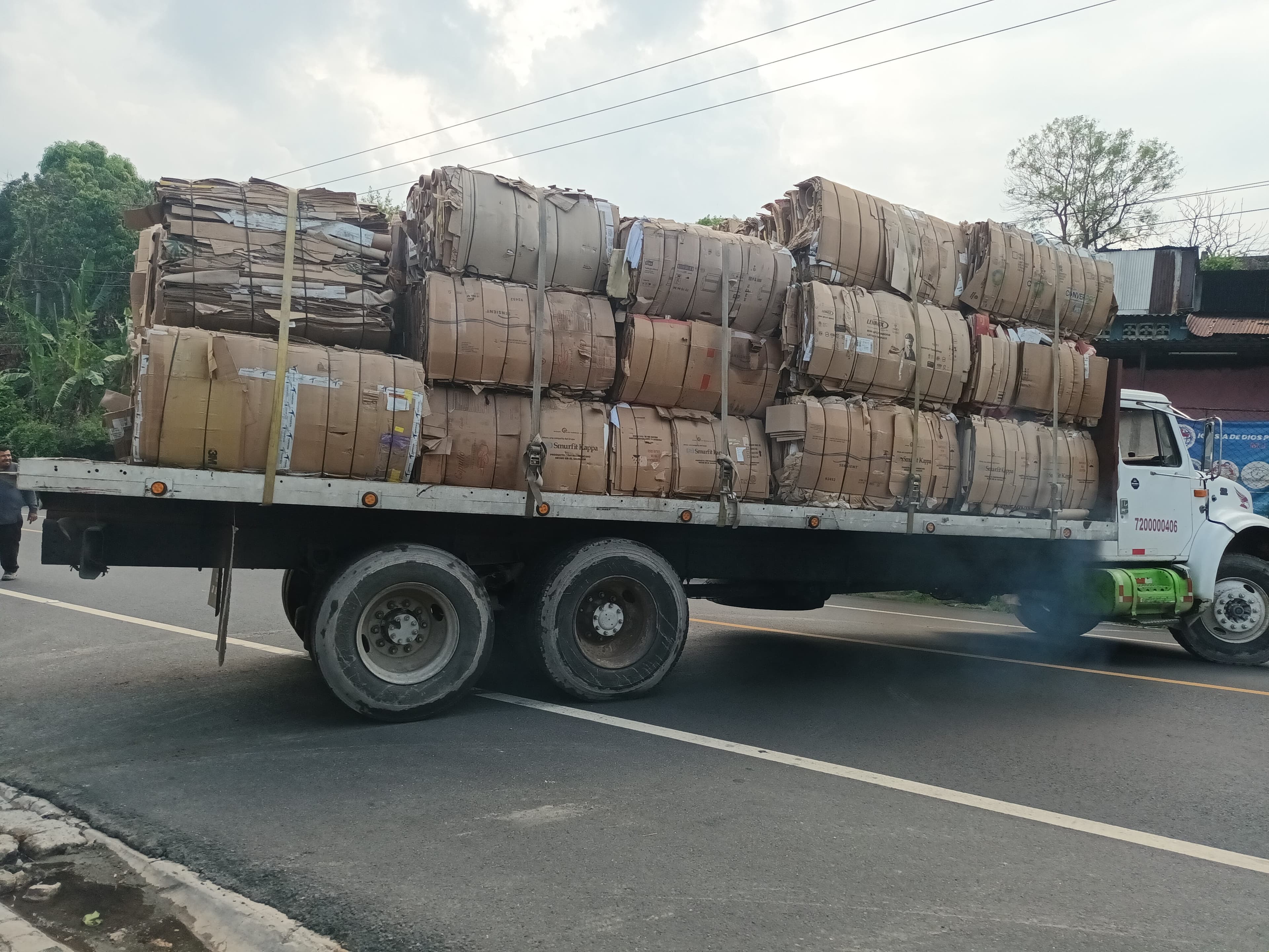 Camión ROMEZA transportando pacas de cartón reciclable en carretera